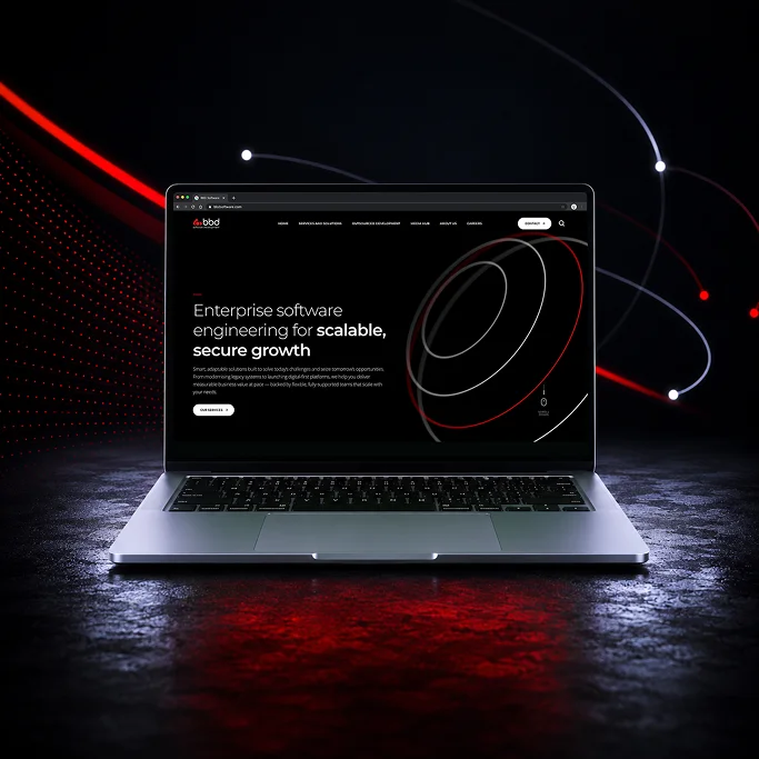 Laptop displaying a modern website for enterprise software engineering with a dark, tech-inspired background.
