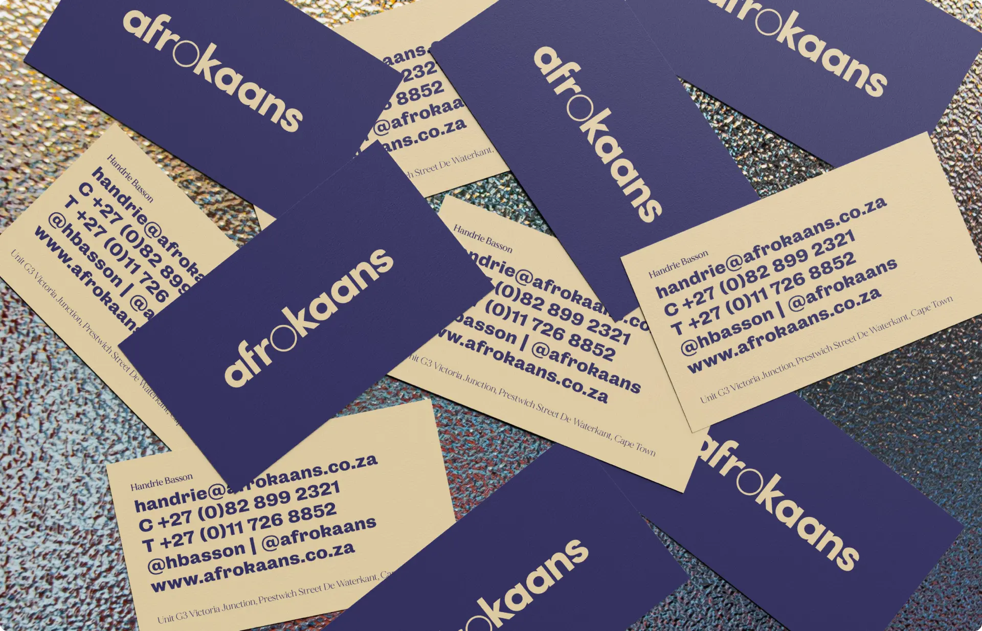 Various business cards for "afrokaans" scattered on a textured surface.