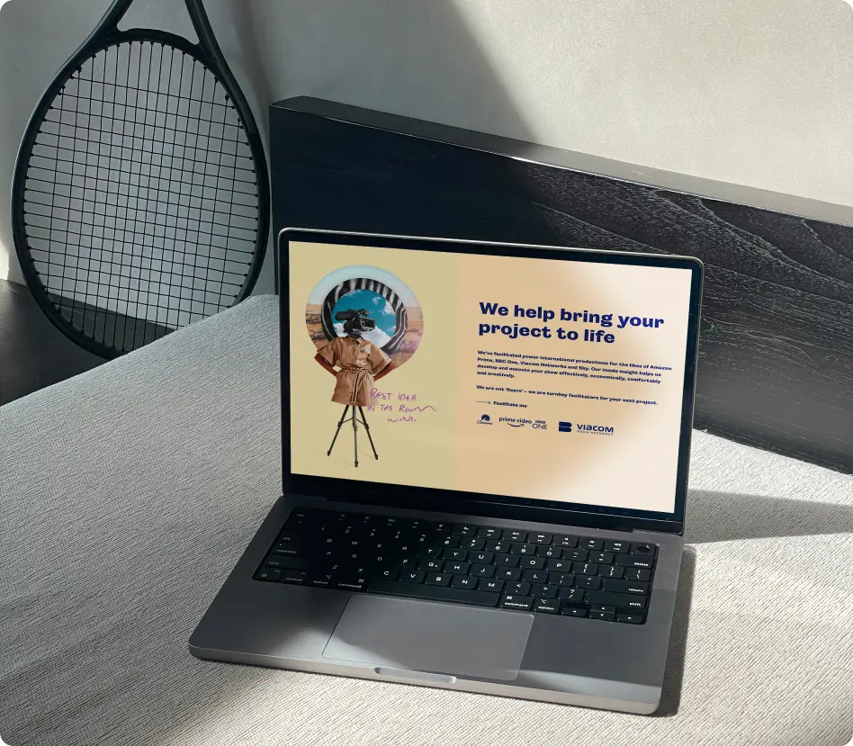 Laptop on a surface displaying a project presentation with a retro design, with a racket in the background.